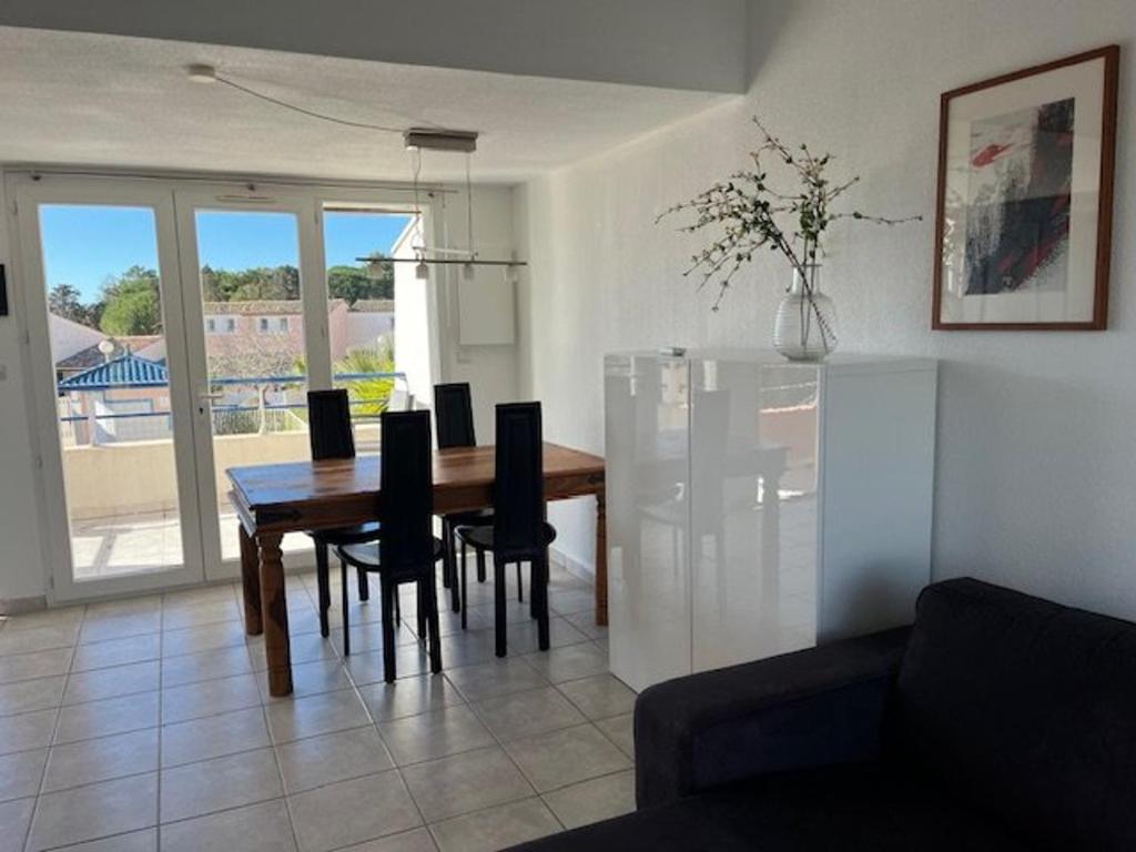 un salon avec une table et des chaises de salle à manger dans l'établissement Appartement T3 avec piscine et golf, Cap d'Agde - FR-1-749-78, au Cap d'Agde