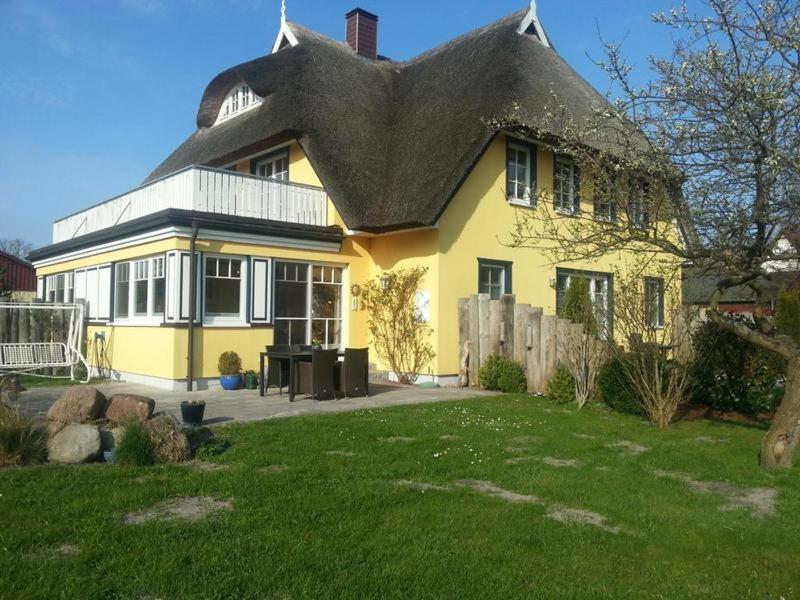 a large yellow house with a black roof at Am Stemsbach in Prerow