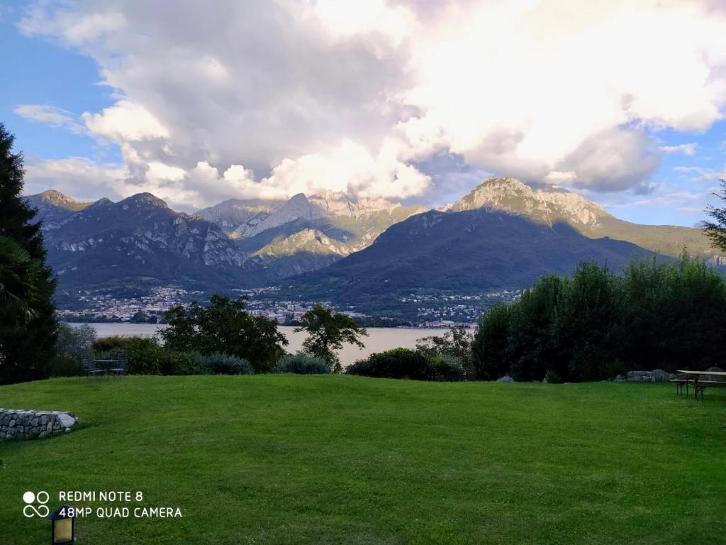 een groen veld met uitzicht op de bergen en een meer bij Villa Oliveto apartments in Oliveto Lario