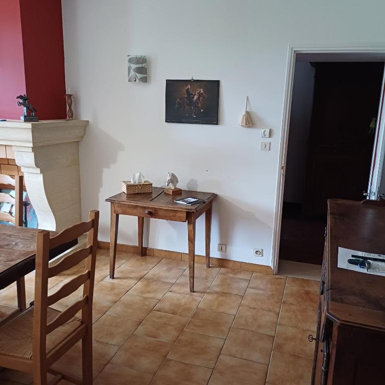 una stanza con un tavolo, un tavolo e una sedia di Gîte la maison du bonheur a Montignac-Charente