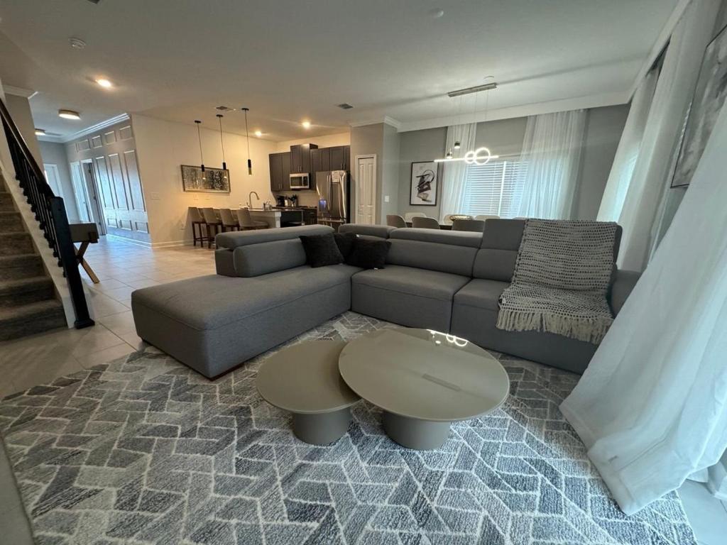 キシミーにある5BR w/Private Pool | Luxury at Storey Lakeのソファとテーブルのあるリビングルーム