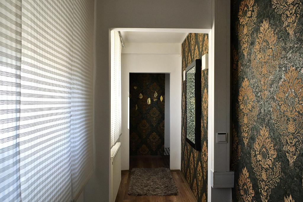 a hallway with ornate wallpaper and a hallway with a door at Ferienwohnungen Halbturn in Halbturn