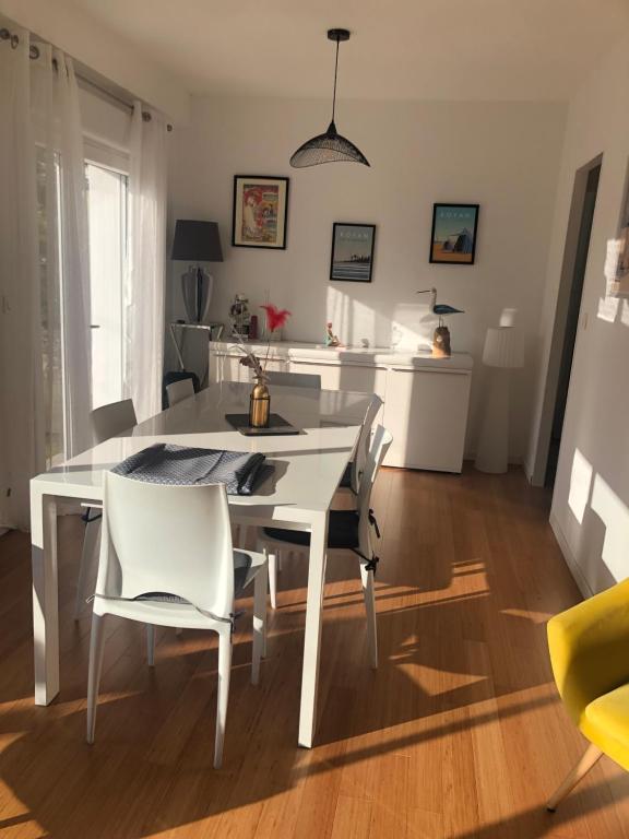 - une table à manger blanche et des chaises dans la cuisine dans l'établissement Villa les peupliers, à Royan