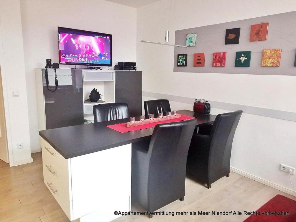 蒂门多弗施特兰德Obj 69 - FeWO Strandläufer 2- bis 4 Personen inkl Strandkorb Top Lage 90 m zum Strand的配有桌椅和电视的客房