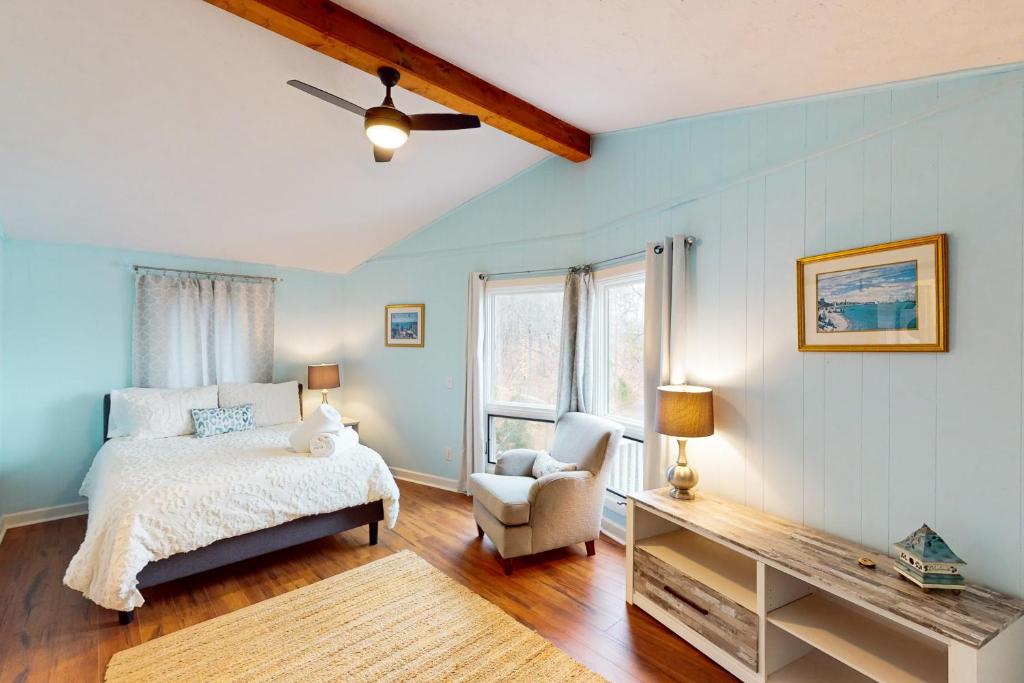 een slaapkamer met een bed en een stoel bij Otter Crossing in Penhook