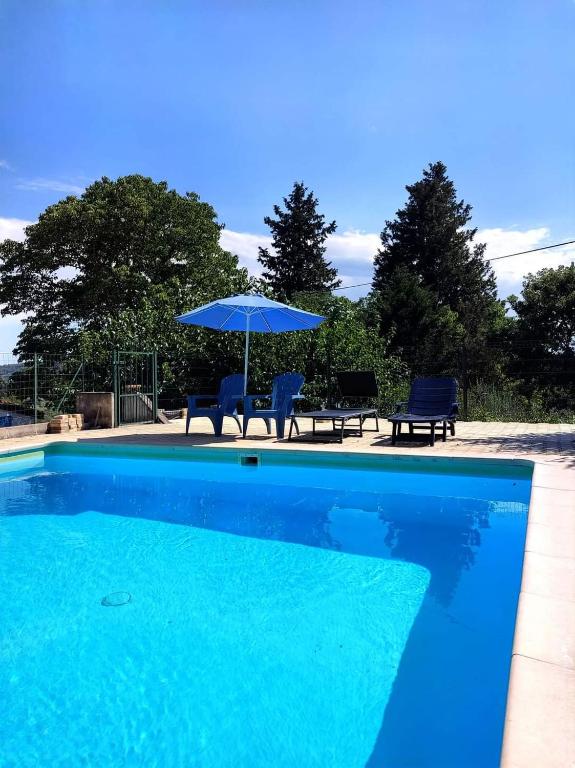 - une piscine bleue avec des chaises et un parasol dans l'établissement LE NORD AU SUD de 3 à 6 personnes près Les Gorges du Verdon, à Villecroze