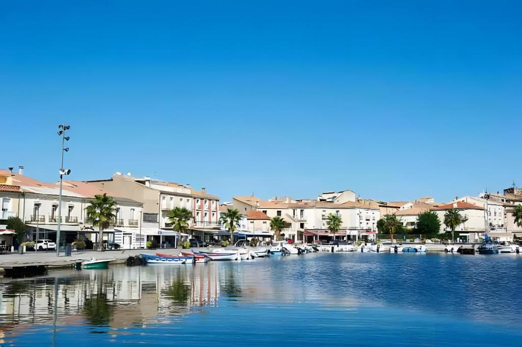 une marina avec des bateaux dans l'eau et des bâtiments dans l'établissement Appartement jusqu'à 8, à Poussan