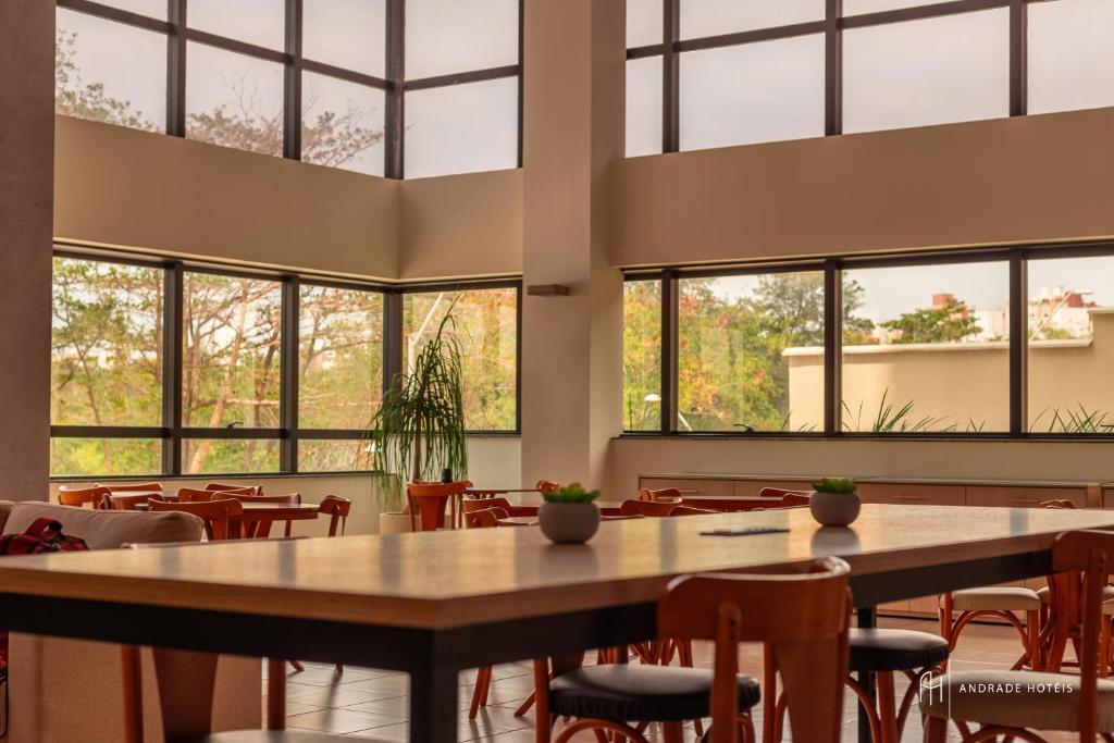 Una gran sala con mesas, sillas y ventanas. en Rede Andrade SLZ, en São Luís