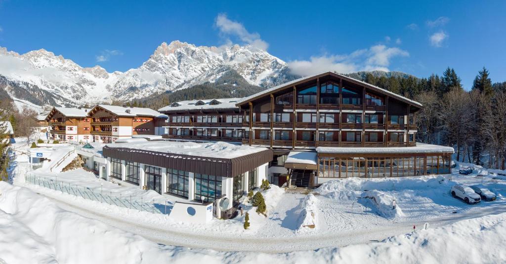 domek na śniegu z górami w tle w obiekcie All Inclusive - Marco Polo Alpina Familien- & Sporthotel w mieście Maria Alm am Steinernen Meer