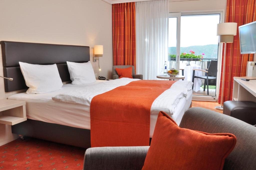 a hotel room with a bed and a balcony at Landgasthof Eiserner Ritter in Boppard