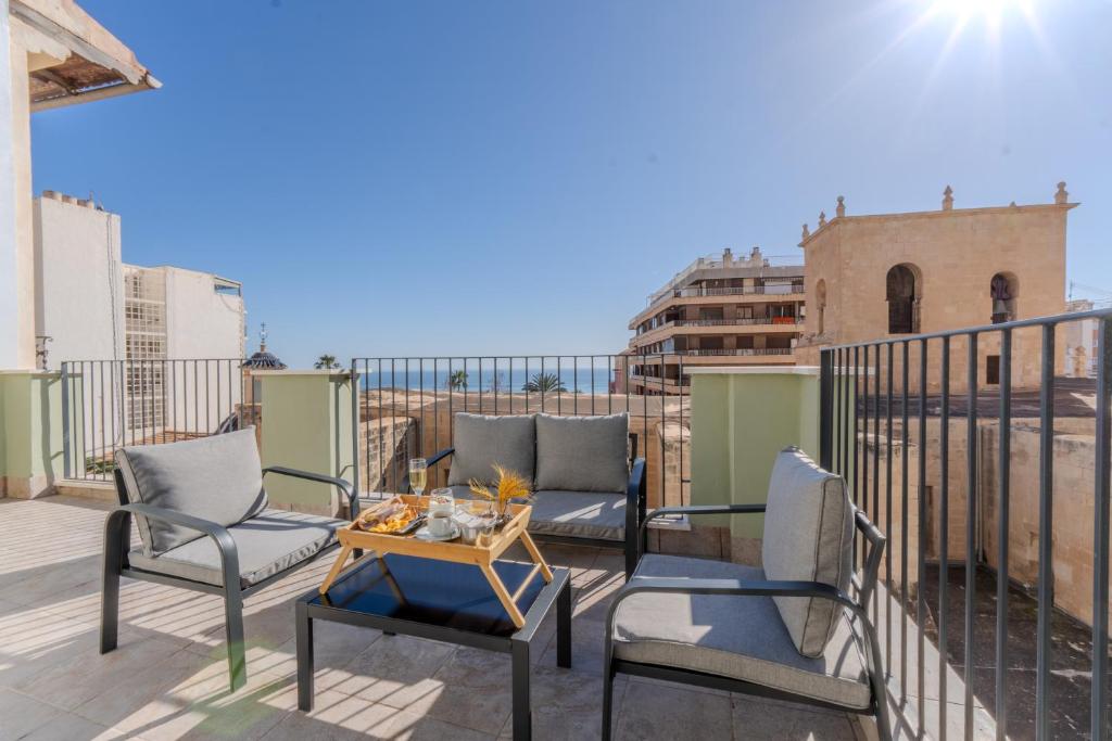 a patio with two chairs and a table on a balcony at Apartamentos La Basílica by BeAlicante in Alicante