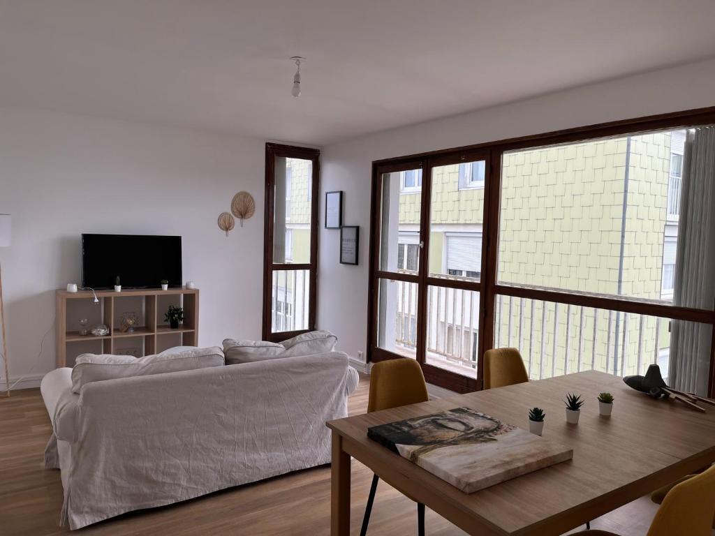 a living room with a couch and a table at Le Familial in Orléans