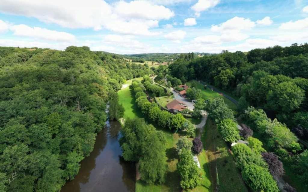 an aerial view of a river in a forest at ZEcamping 3 étoiles pet friendly en bord de rivière avec une plage de sable in Jumilhac-le-Grand