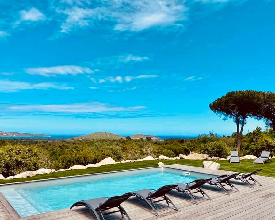 basen z krzesłami i widokiem na ocean w obiekcie La Villa Cilagna w mieście Cirendinu
