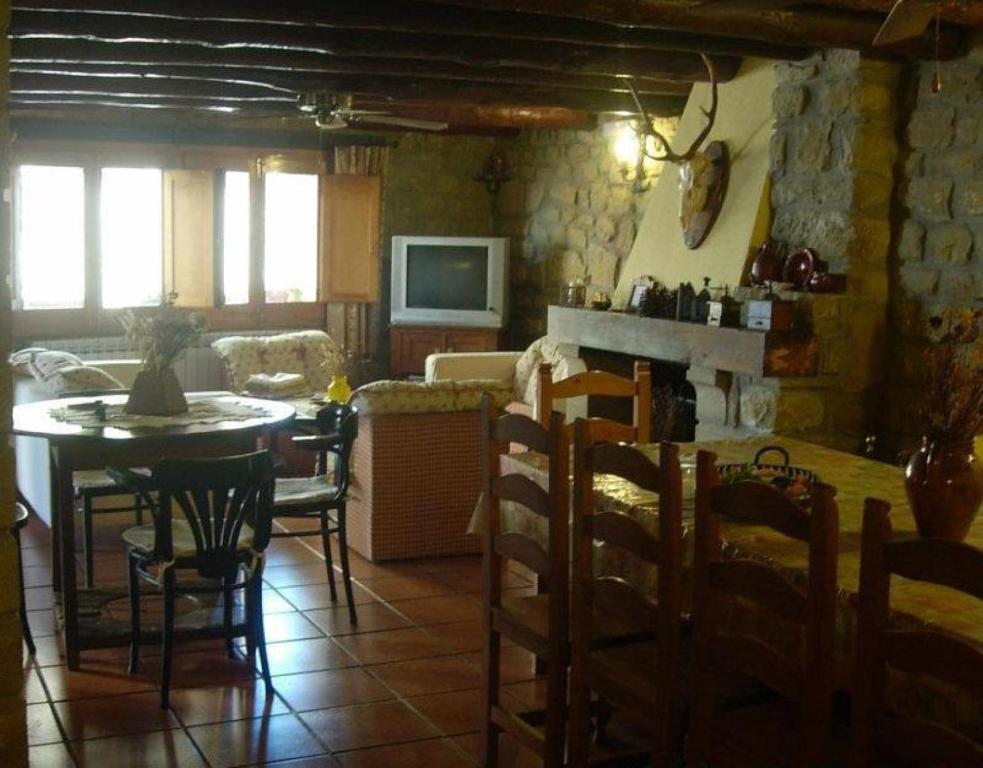 a living room with a table and chairs and a couch at Casa El Rey in Murillo de Gállego
