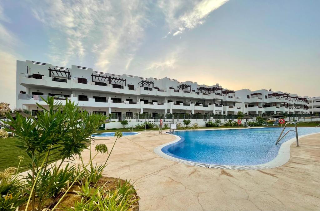 a large apartment building with a large swimming pool at Casa Arona in San Juan de los Terreros