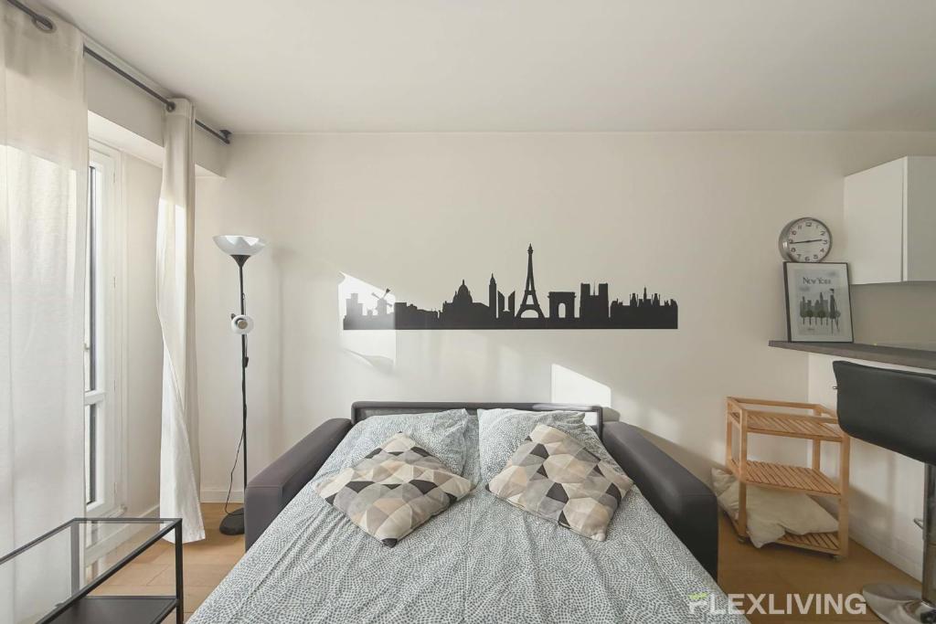 une chambre avec un lit avec deux oreillers dans l'établissement Flexliving - Studio - Piver, à Paris