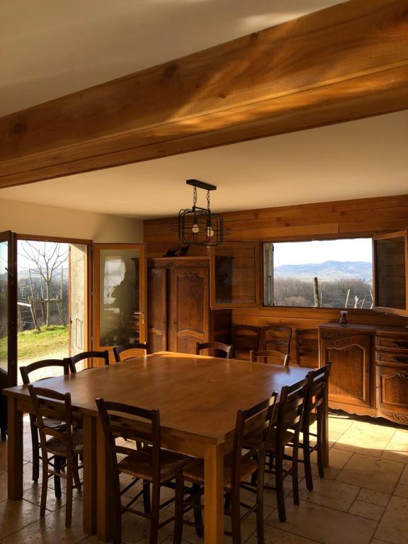 une salle à manger avec une table et des chaises en bois dans l'établissement Gite La Grange sur les Bois, à Aiguebelette-le-Lac