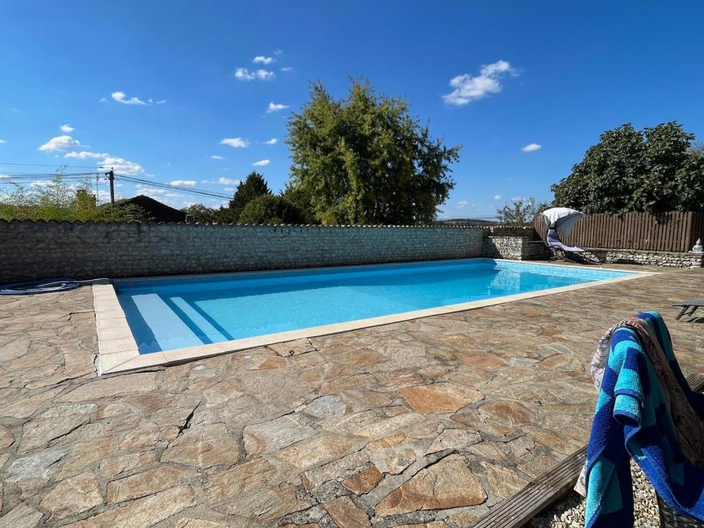 - une piscine dans une cour avec une terrasse en pierre dans l'établissement Beautiful Gite, Private Pool, Magnificent views!!!, à Nanteuil-Auriac-de-Bourzac
