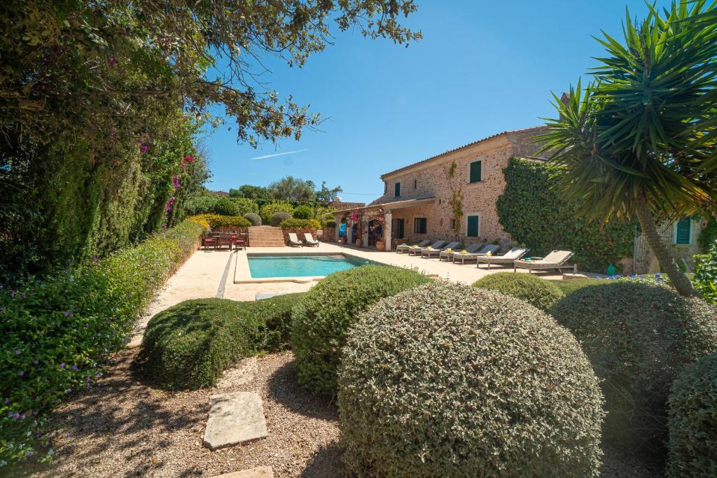 una casa con piscina y algunos arbustos en Finca Can Pau, en Calonge