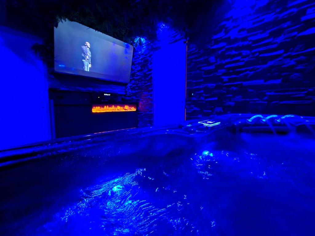 MieussyにあるCocon Spa & Cinema Roomのテレビ付きの客室で、バスタブが備わります。