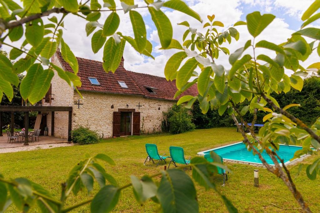 une maison avec une cour avec deux chaises et une piscine dans l'établissement Maison de charme proche Sancerre avec piscine, à Groises