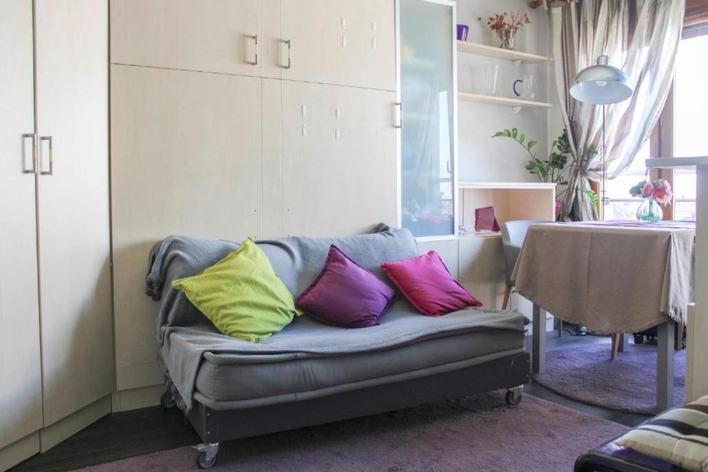 un canapé avec quatre coussins colorés dessus dans un salon dans l'établissement Studio Charonne, à Paris