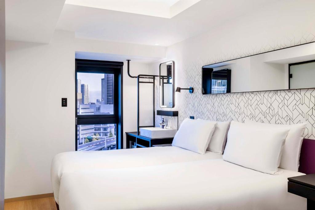 Postel nebo postele na pokoji v ubytování YOTEL Tokyo Ginza