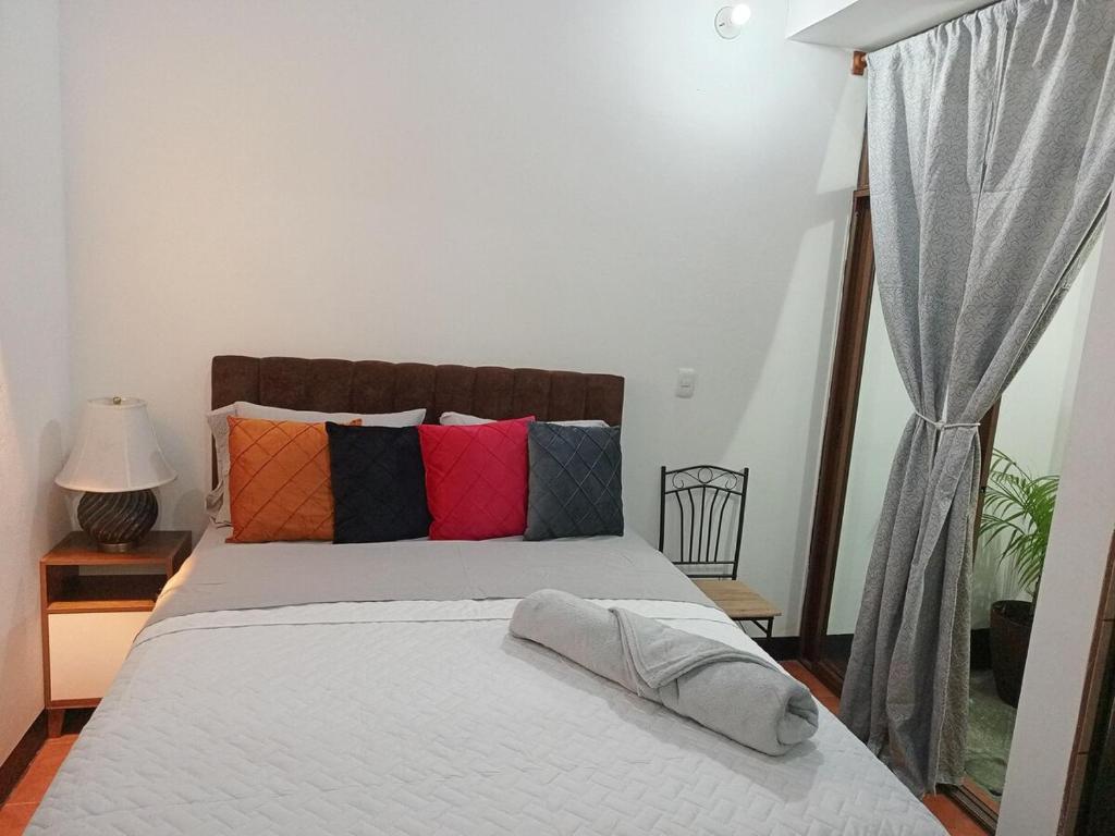 a bedroom with a bed with colorful pillows at Apartment T46 in Antigua Guatemala