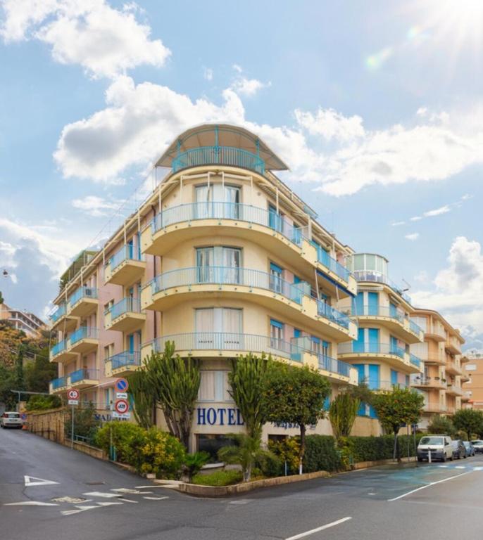 アラッシオにあるHotel Majestic by LVG Hotel Collectionのホテルの看板が貼られた大きな黄色の建物