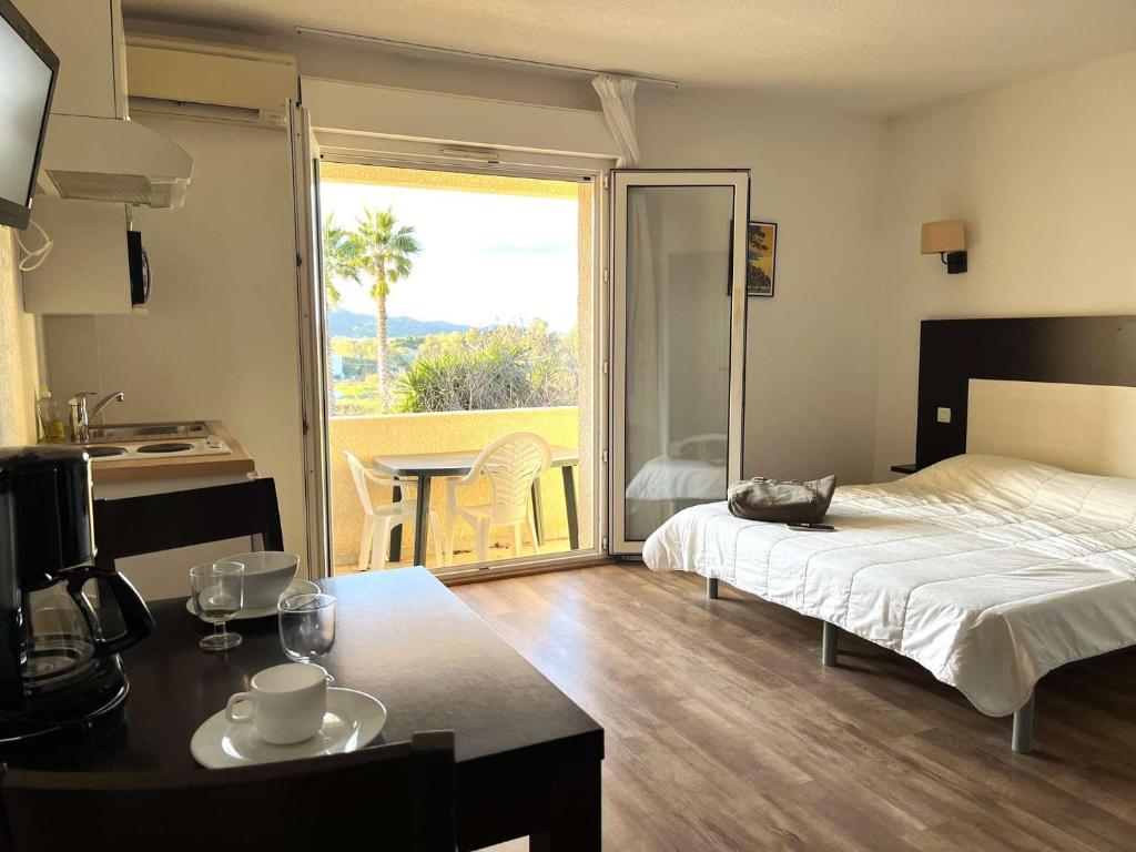 une chambre avec un lit et une table et une cuisine dans l'établissement SAINT-FLORENT Résidence piscine Studio 2 personnes FLO130, à Saint-Florent