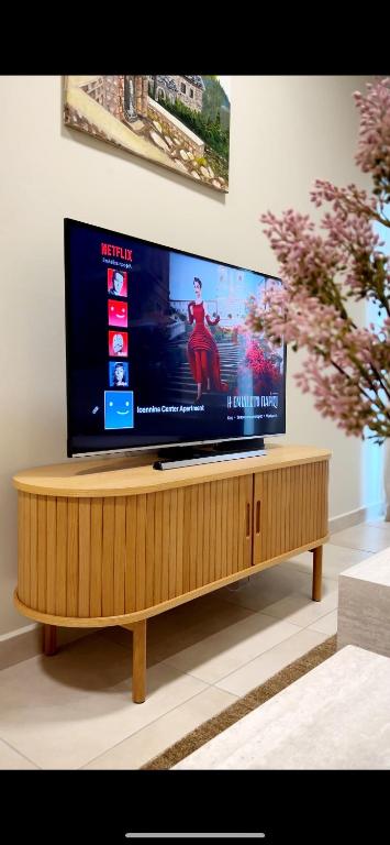a flat screen tv on a wooden stand in a living room at Ioannina Center Apartment in Ioannina