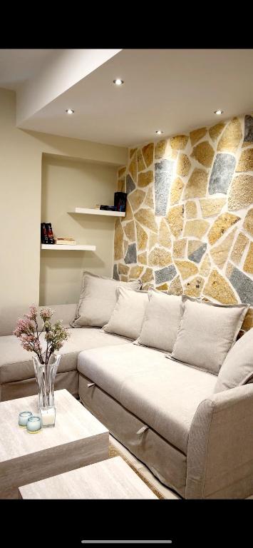 a living room with a couch and a stone wall at Ioannina Center Apartment in Ioannina