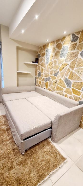 a large bed in a room with a stone wall at Ioannina Center Apartment in Ioannina