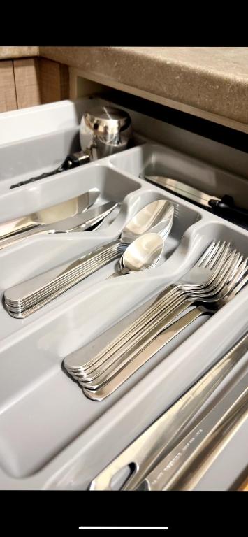 a white tray with silver utensils in a sink at Ioannina Center Apartment in Ioannina
