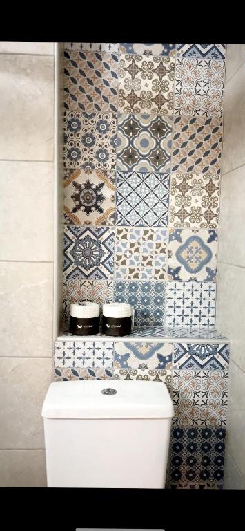 a bathroom with blue and white tiles on the wall at Ioannina Center Apartment in Ioannina