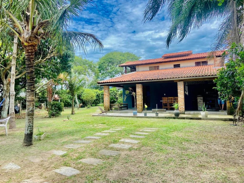 una casa con una palmera delante en Casa na Praia e Campo, en Garopaba