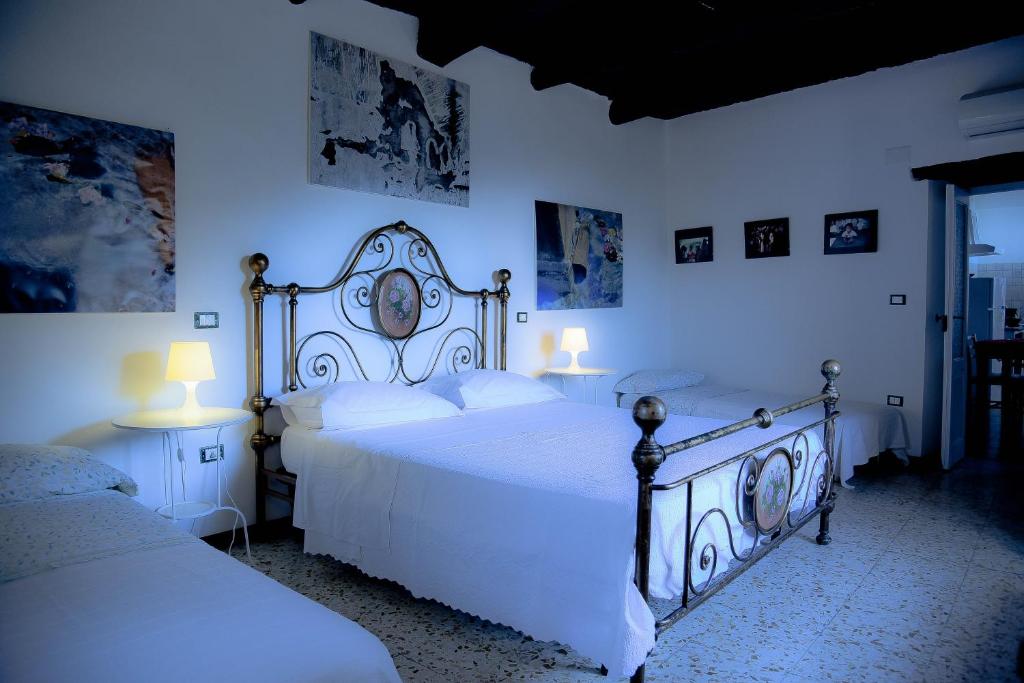 a white bedroom with two beds and two lamps at Sentieri Luminosi in SantʼAgata deʼ Goti