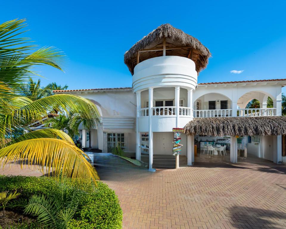 ein großes weißes Gebäude mit Strohdach in der Unterkunft Bliss Bonaire by Boutique Bonaire Unique Resorts in Kralendijk