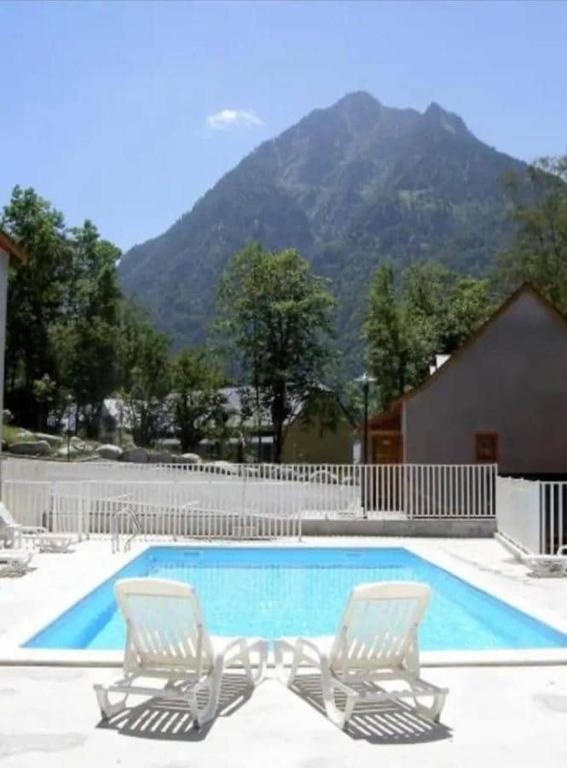 2 chaises et une piscine avec une montagne dans l'établissement Studio vue montagnes RDC piscine, à Cauterets