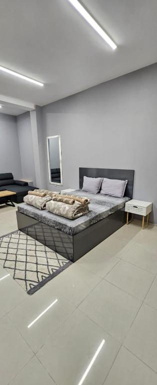 Un dormitorio con una cama en una habitación blanca. en Ново! New Studio PANDORA, en Sliven