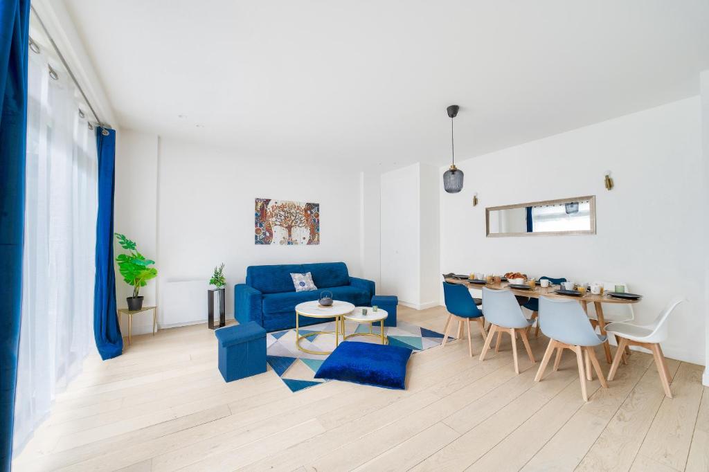 un salon avec un canapé bleu et une table dans l'établissement Stylish 3 bdr & Garden Oasis on the Edge of Paris, à Saint-Mandé