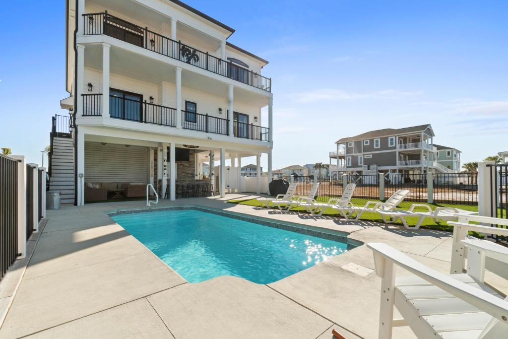 a swimming pool in front of a building with a house at The Grand View 5bedrooms 5 Ba, Elevator, Heated Pool in Ocean Isle Beach