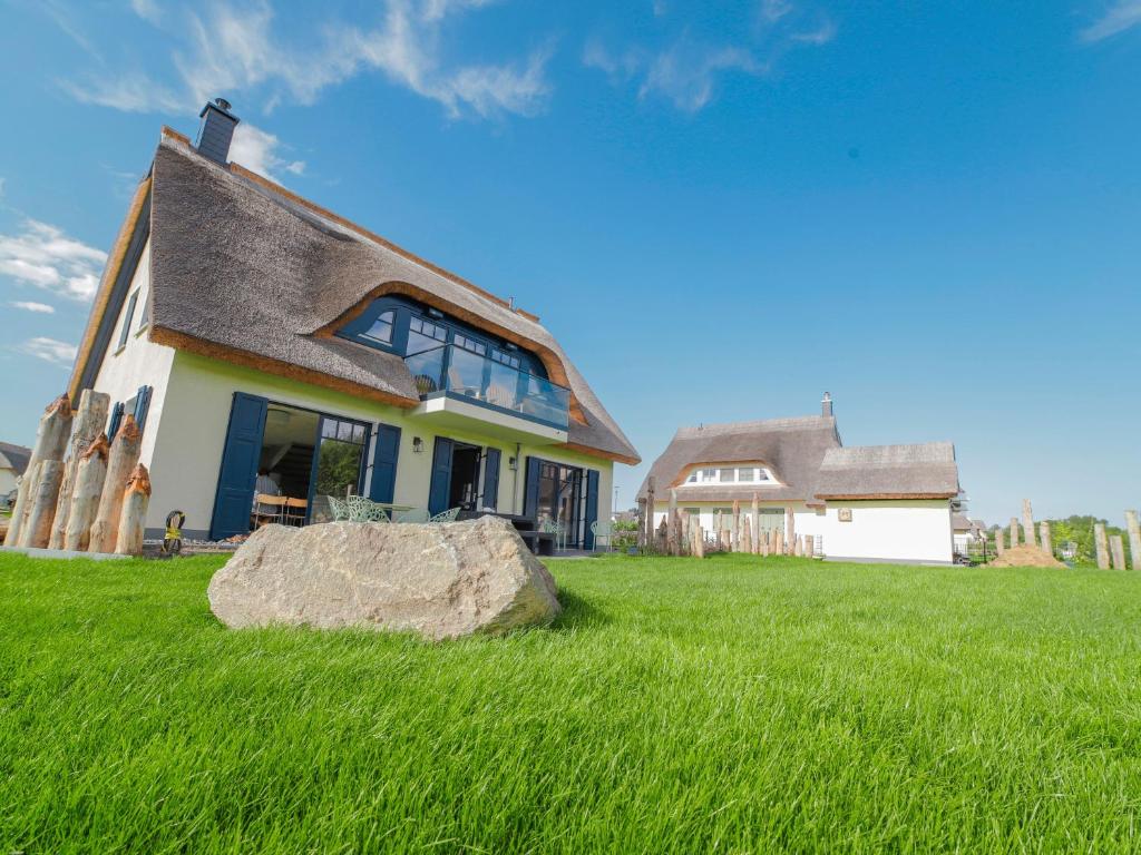 a house with a large rock in the grass at Ferienhaus Emma in Kramerhof