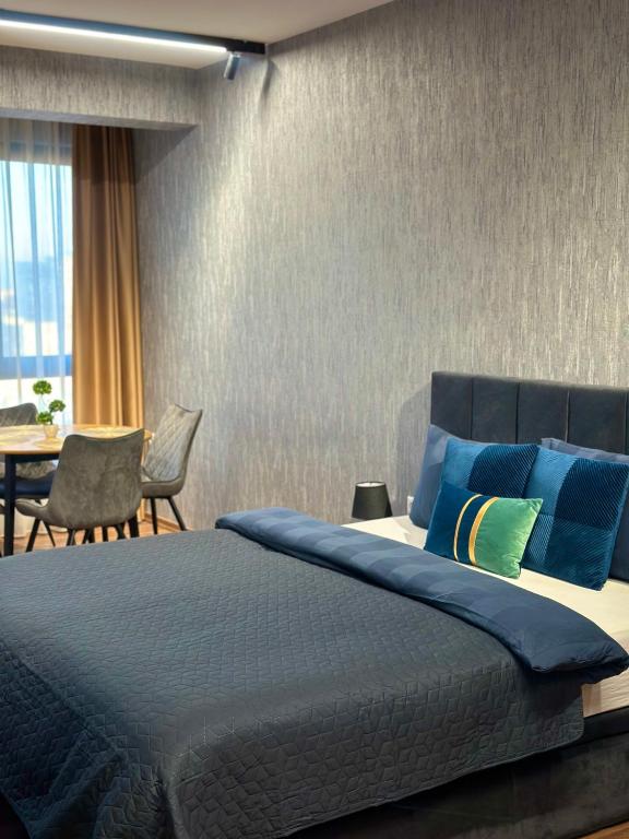 a bedroom with a bed and a table with chairs at West Point Luxury studio in Plovdiv
