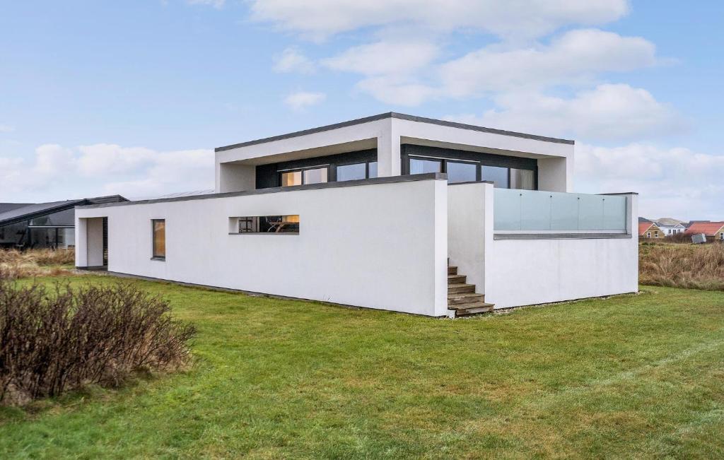 a large white house with a grass yard at Cozy Home In Ulfborg With Wifi in Ulfborg
