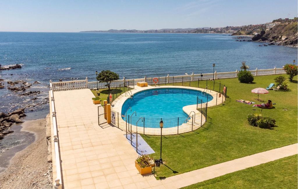 an overhead view of a swimming pool next to the ocean at Cozy Apartment In Benalmadena With Wifi in Benalmádena