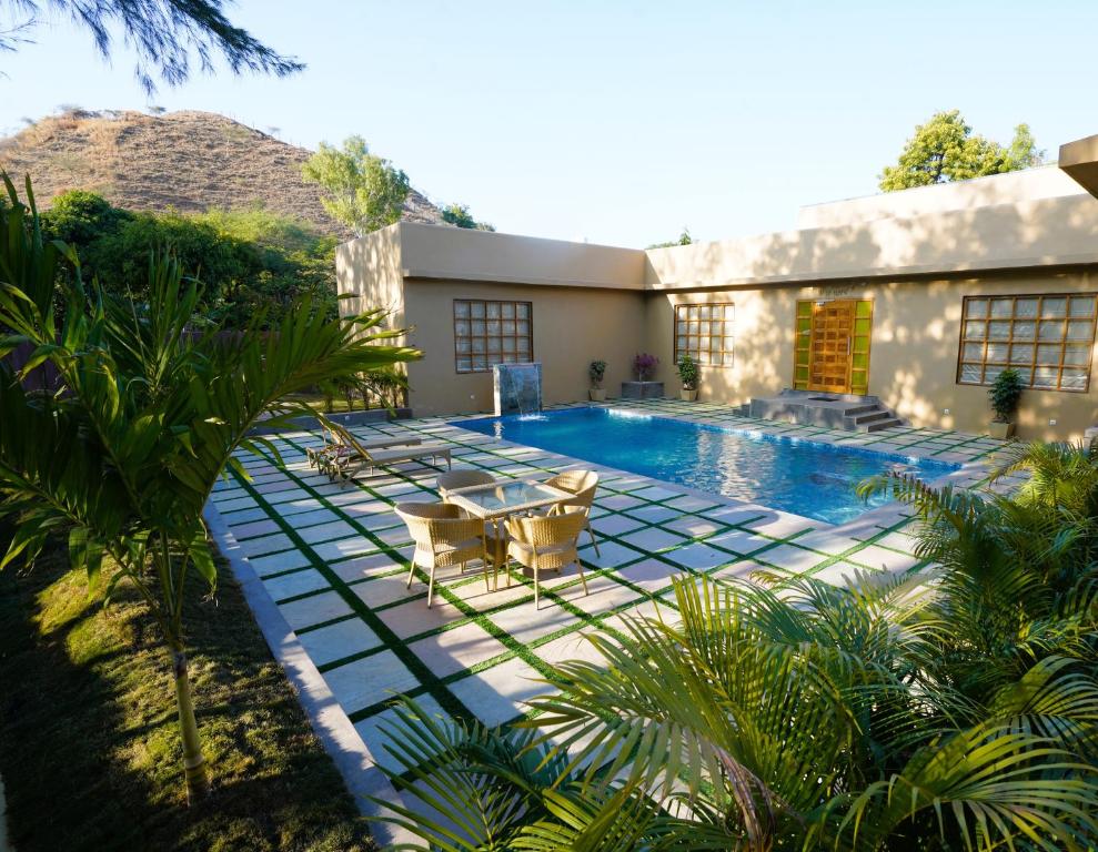 a swimming pool with a table and chairs next to a building at Arvita Villa with Swimming Pool in Rāma