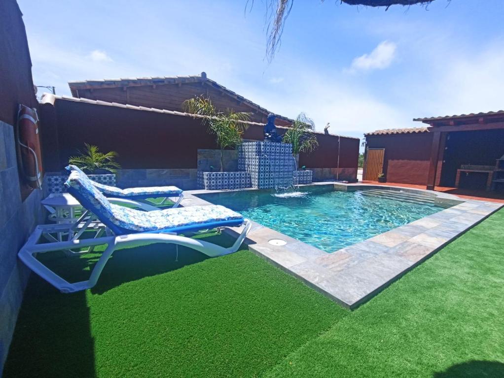 einen Pool mit zwei Liegestühlen im Hof in der Unterkunft El Refugio de Conil Ideal Familias in Conil de la Frontera