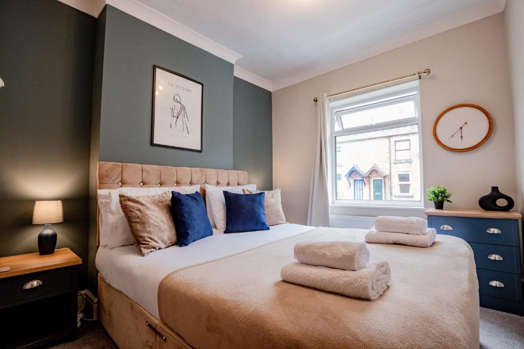a bedroom with a large bed with blue pillows at Host & Stay - Mayfield House in Ashbourne